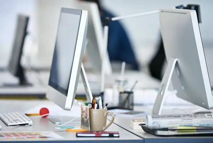 Un bureau moderne équipé d'ordinateurs, symbolisant l'environnement de travail numérique et professionnel de Plyvexia Agency